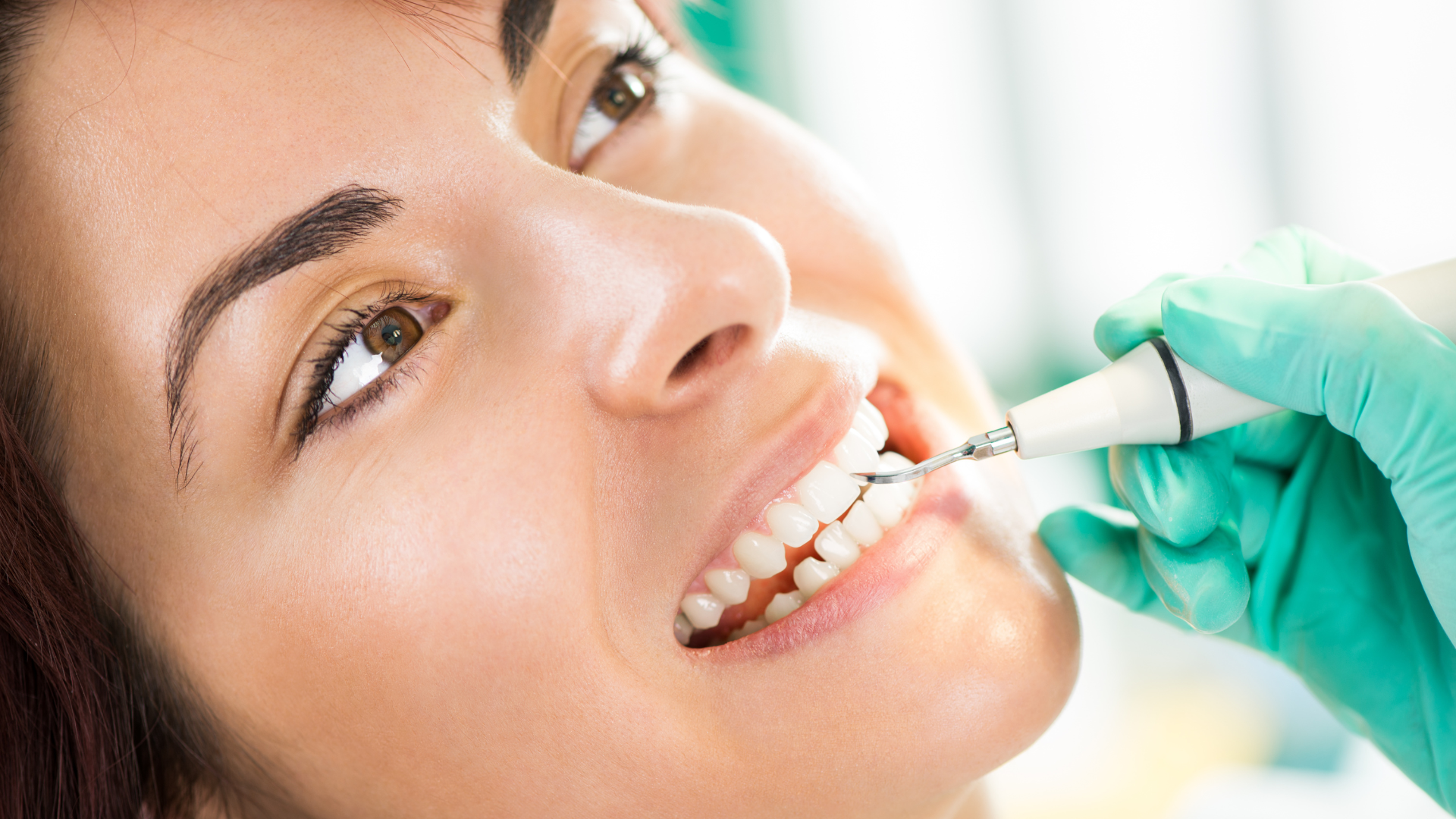 A woman is getting her teeth examined by a dentist.