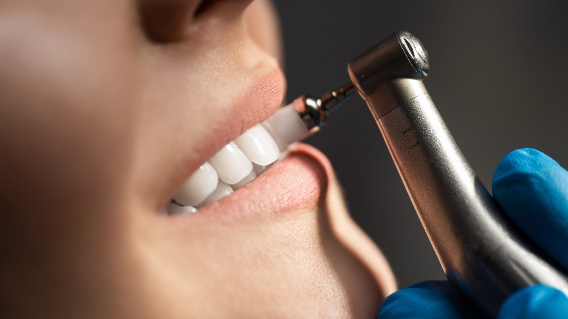 A dentist is examining a woman 's teeth in a dental office.