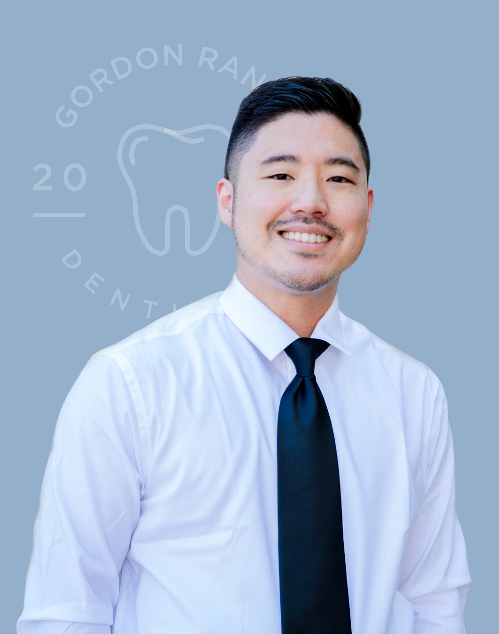A man in a white shirt and black tie is smiling