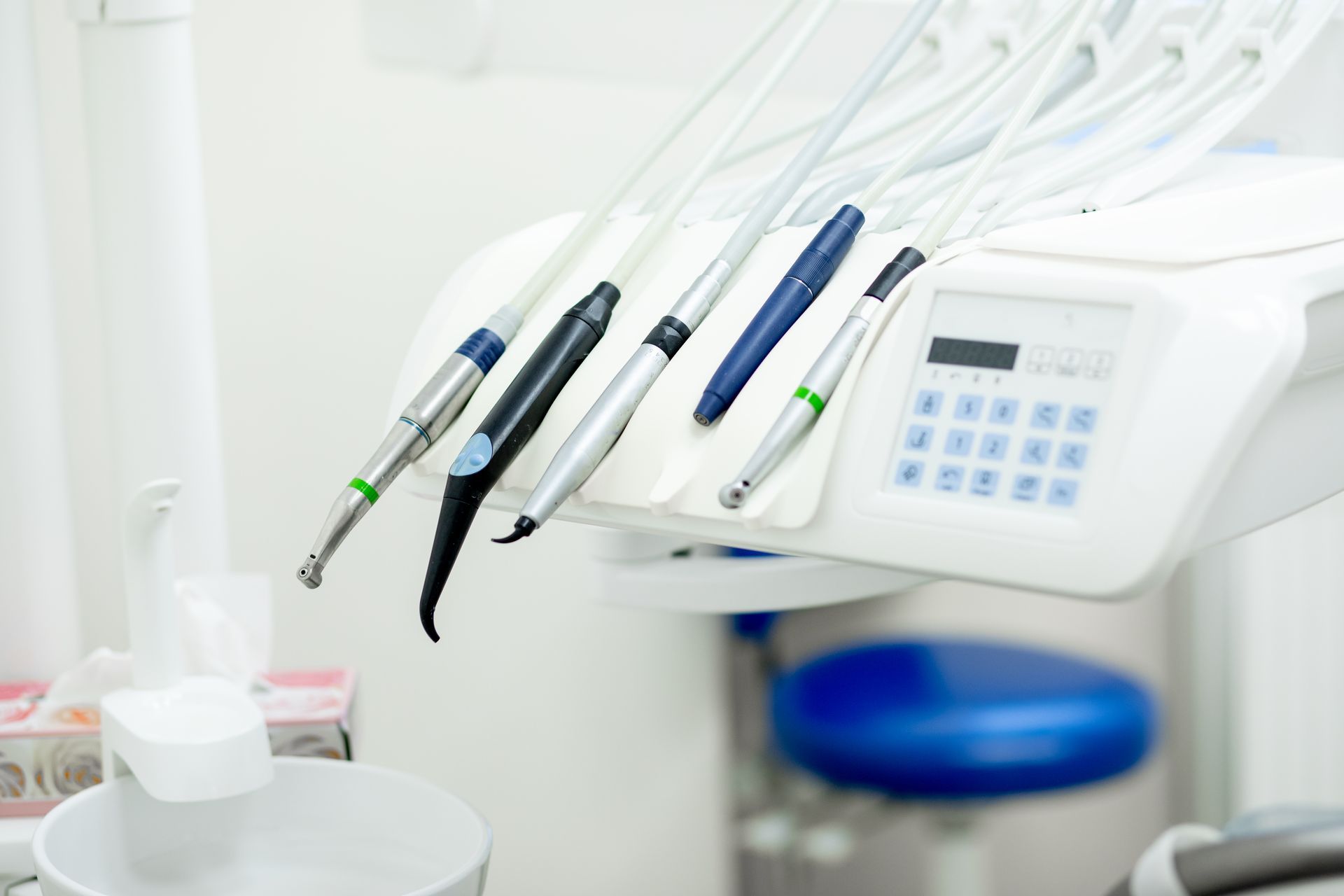 A close up of a dental chair with dental instruments on it.