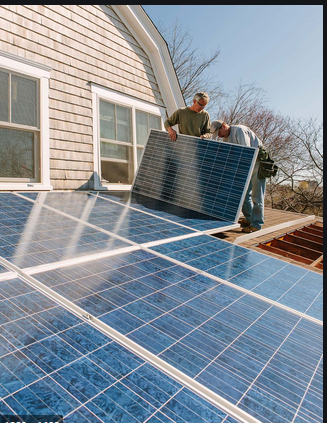 Two men are installing solar panels on the roof of a house