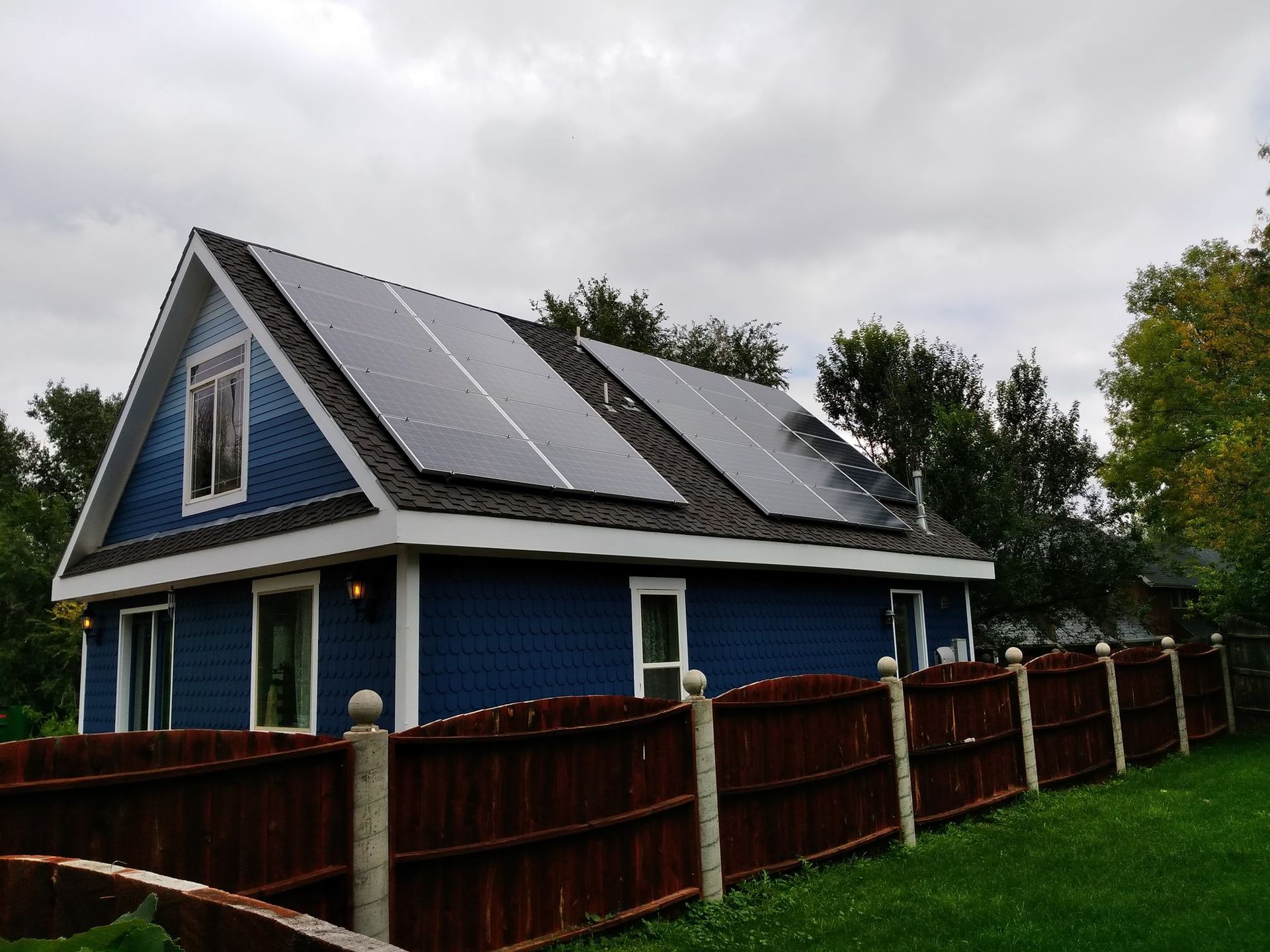 A blue house with solar panels on the roof