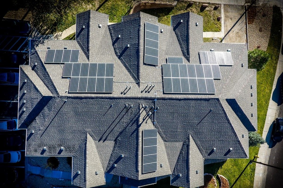 An aerial view of a house with solar panels on the roof.