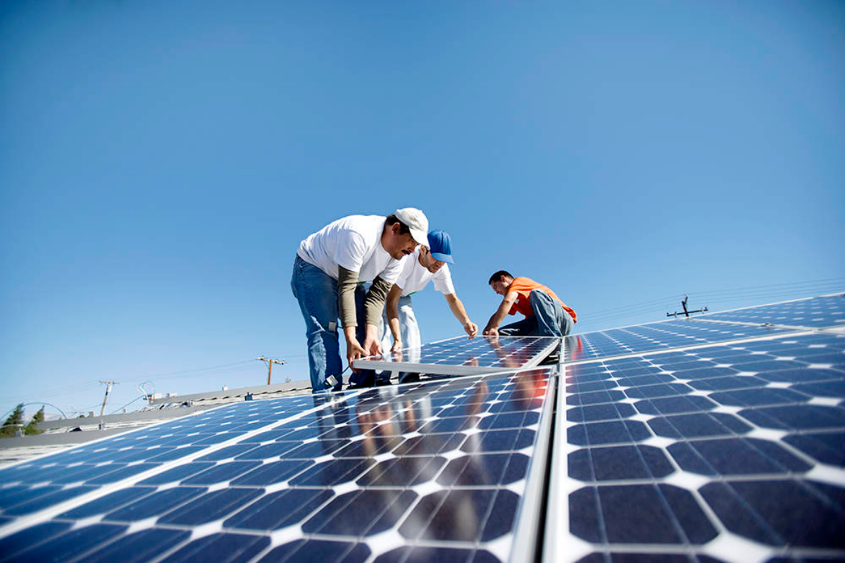 Two men are installing solar panels on a roof.