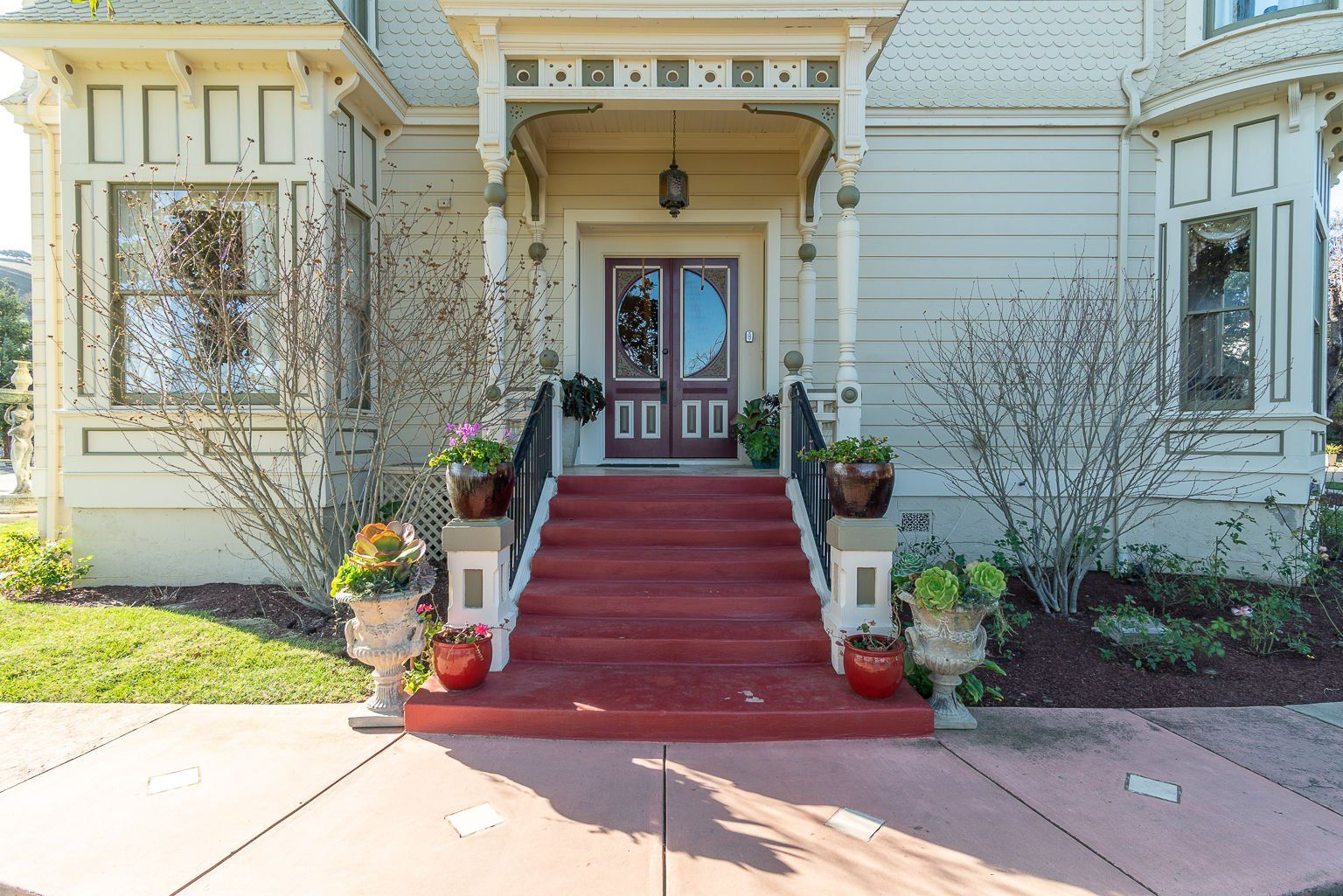 A large white house with red stairs leading up to the front door.