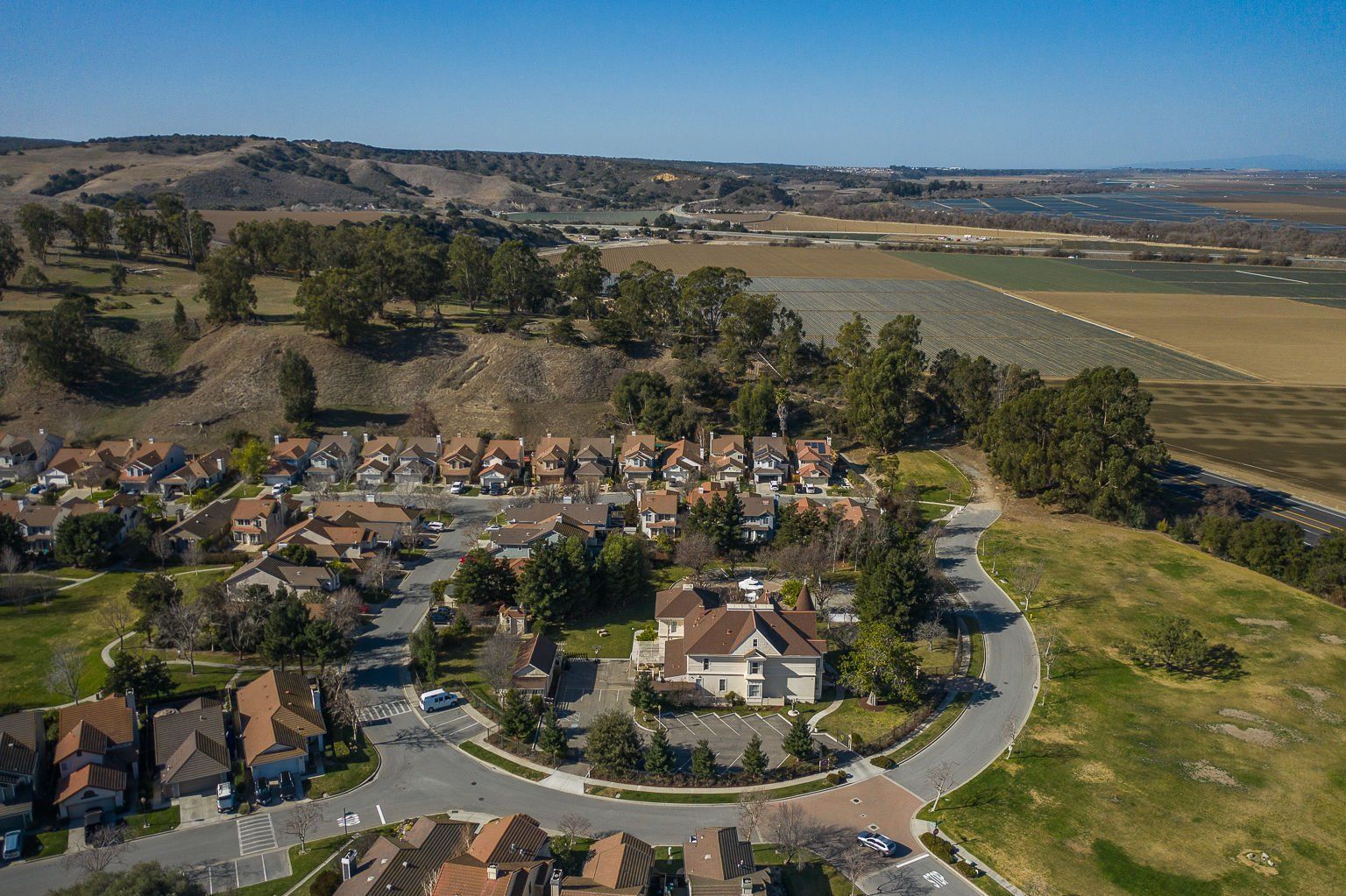 An aerial view of a residential area with houses and a golf course surrounding Chateau Coralini.