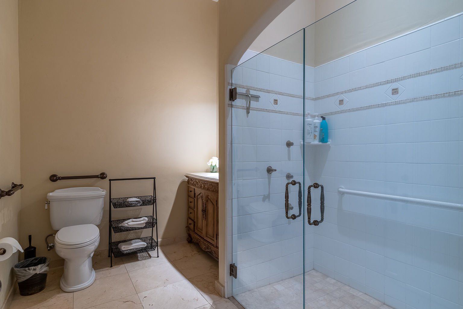 A bathroom with a toilet , sink and walk in shower.