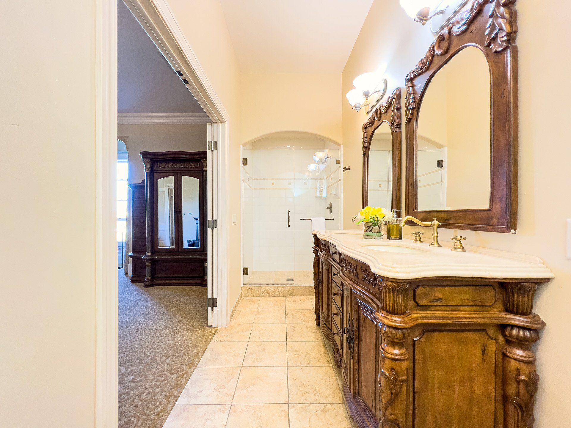A bathroom with two sinks , a mirror and a walk in shower.
