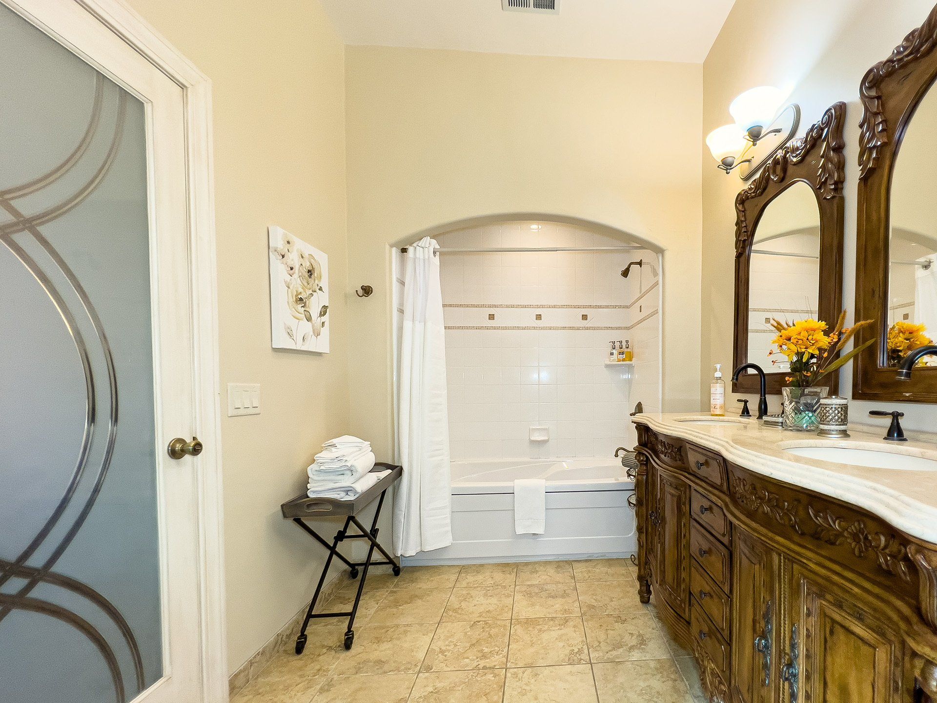 A bathroom with a tub , sink and mirrors