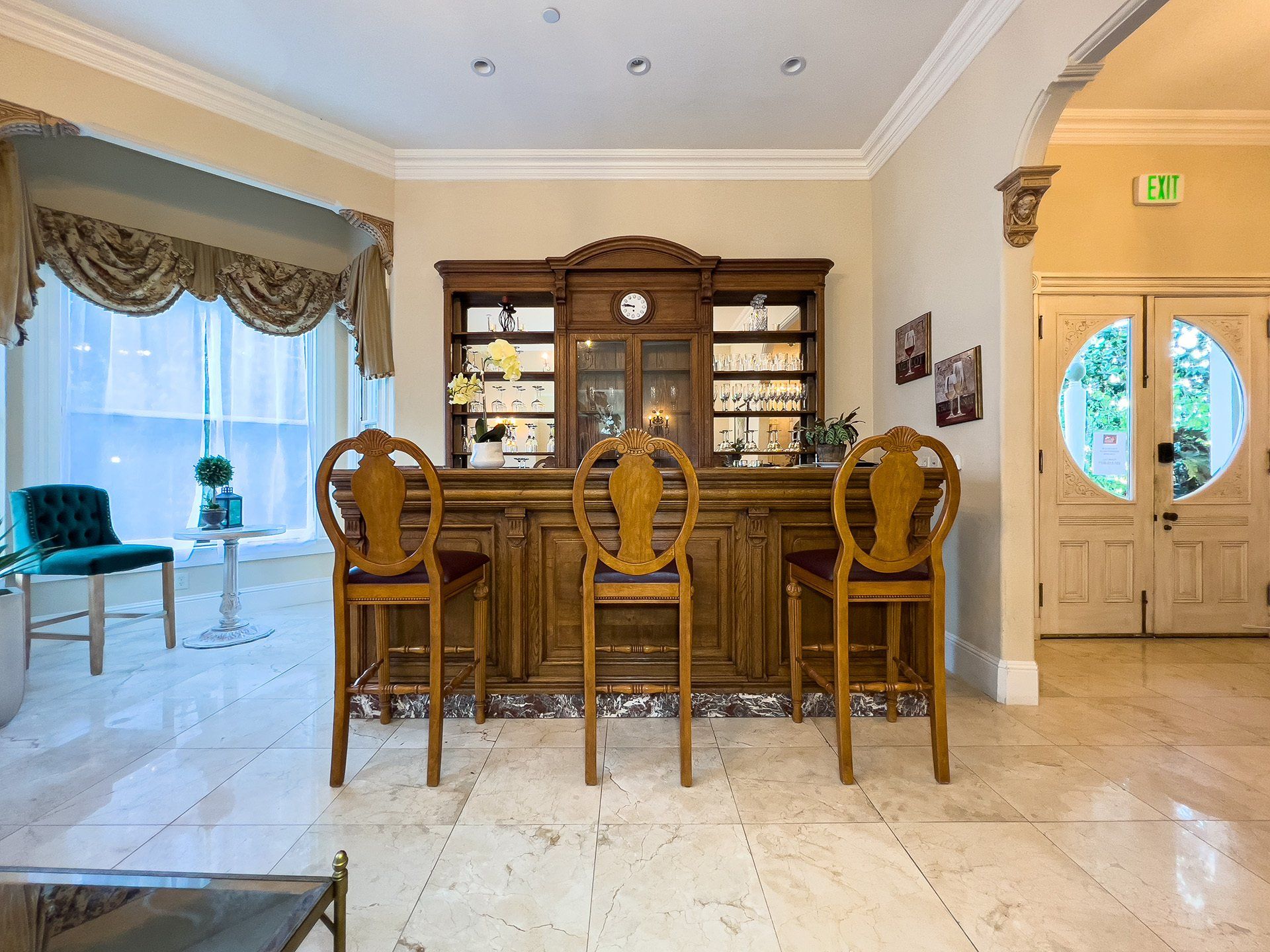 There is a bar with three chairs in the middle of the room.