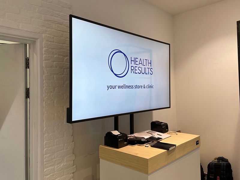 A large flat screen tv is hanging on the wall above a counter.