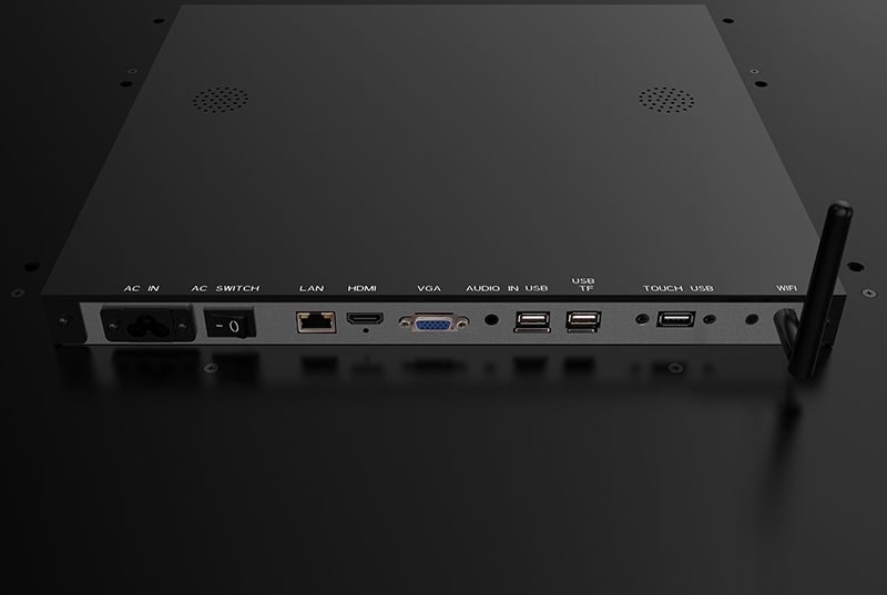 The back of a computer monitor with a wireless antenna attached to it.