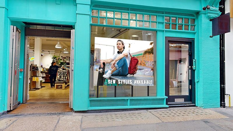A store front with a picture of a woman sitting in the window.