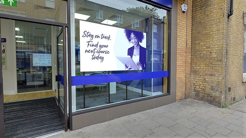 A store front with a large screen in the window.