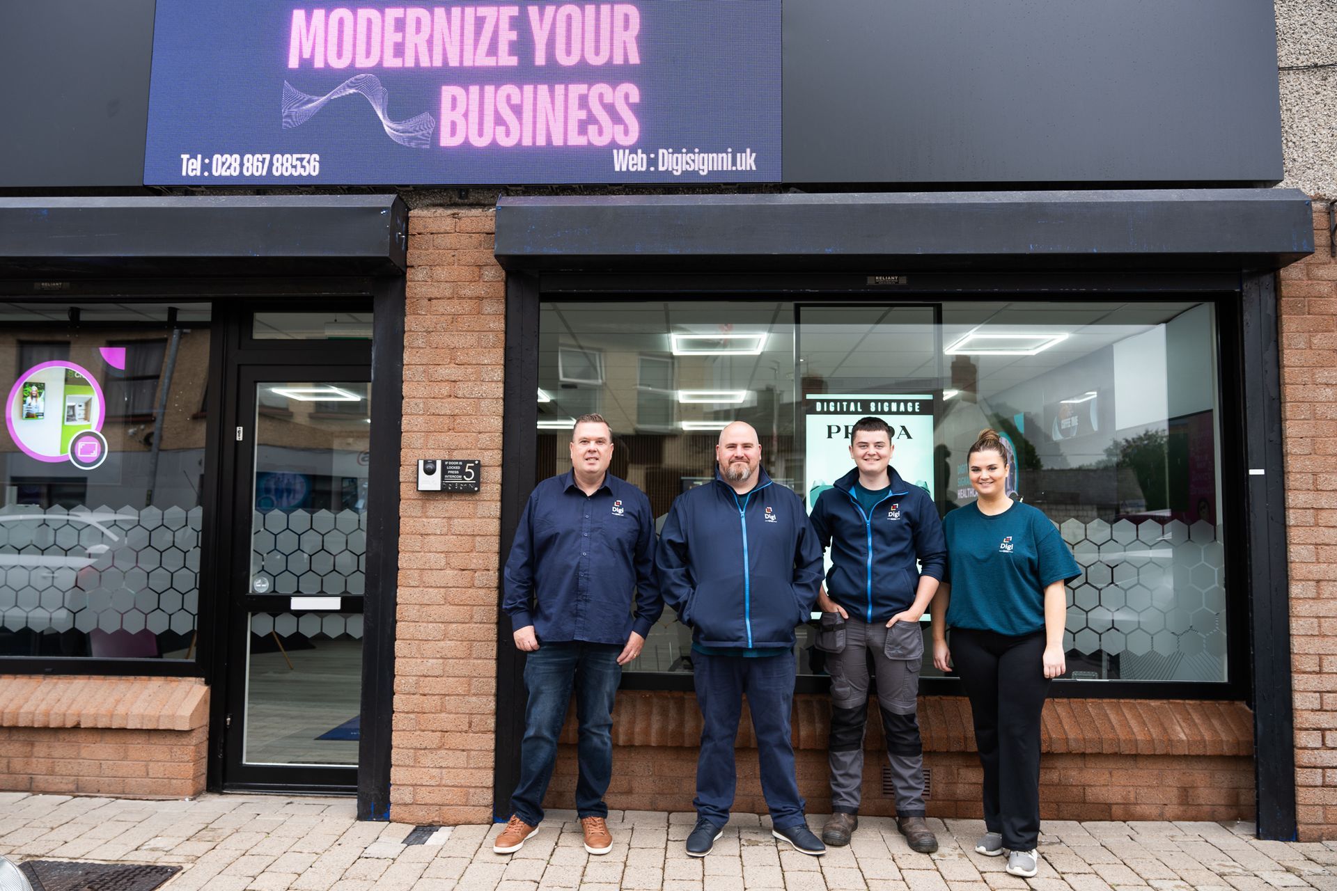 A group of people standing in front of a building with a sign that says modernize your business.