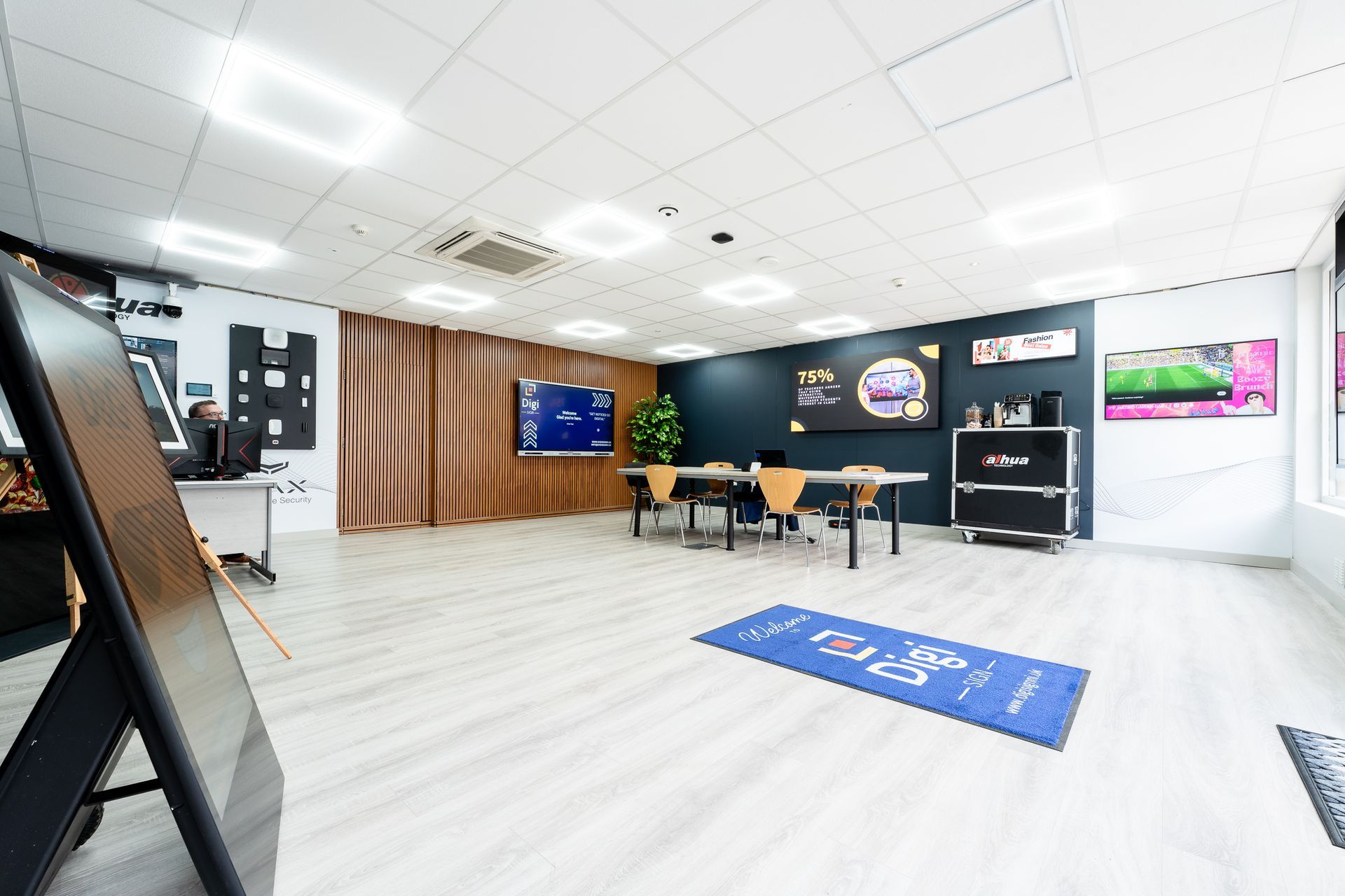 A large room with tables and chairs and a blue rug on the floor.