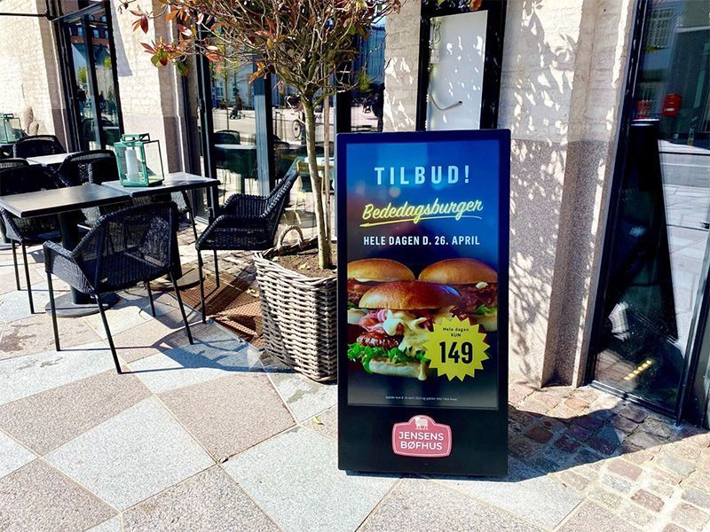 A sign that says tilbud on it is outside of a restaurant.