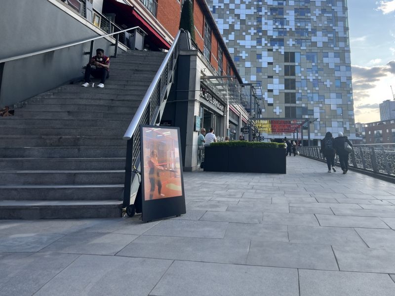 A man sits on a set of stairs in front of a building