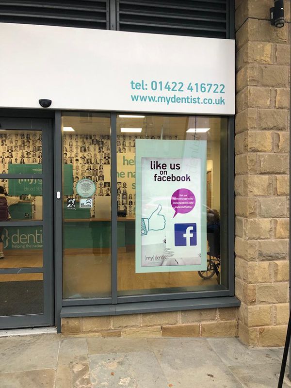 A dental office with a sign that says like us facebook