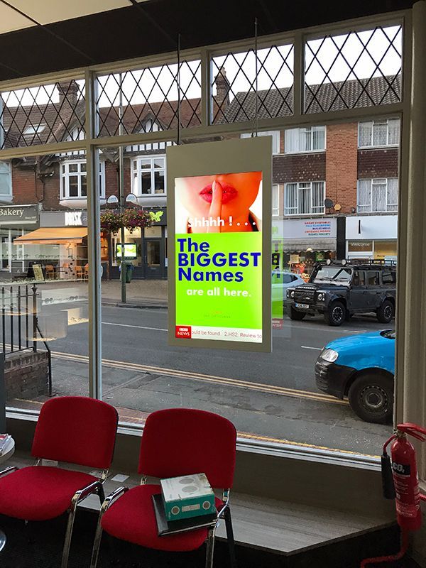 A waiting room with red chairs and a sign that says the biggest names are all here.