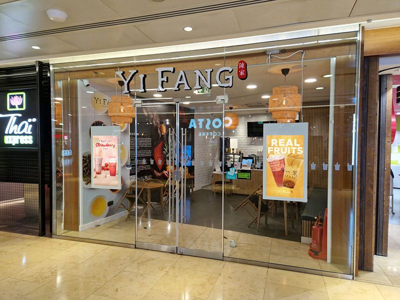 A restaurant with a glass door and a sign that says `` real fruits ''.