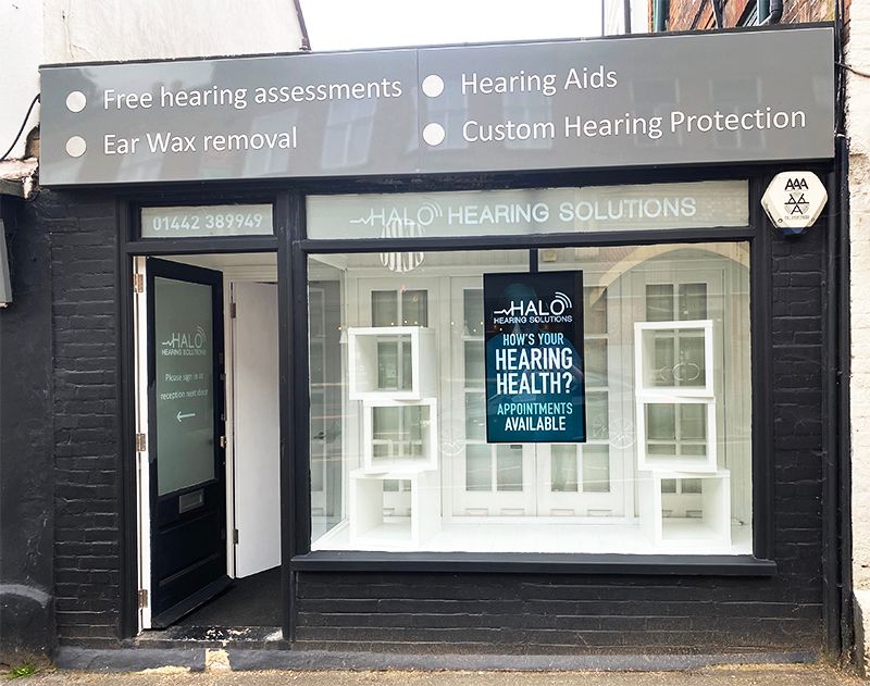 A black building with a sign that says hearing solutions on it.