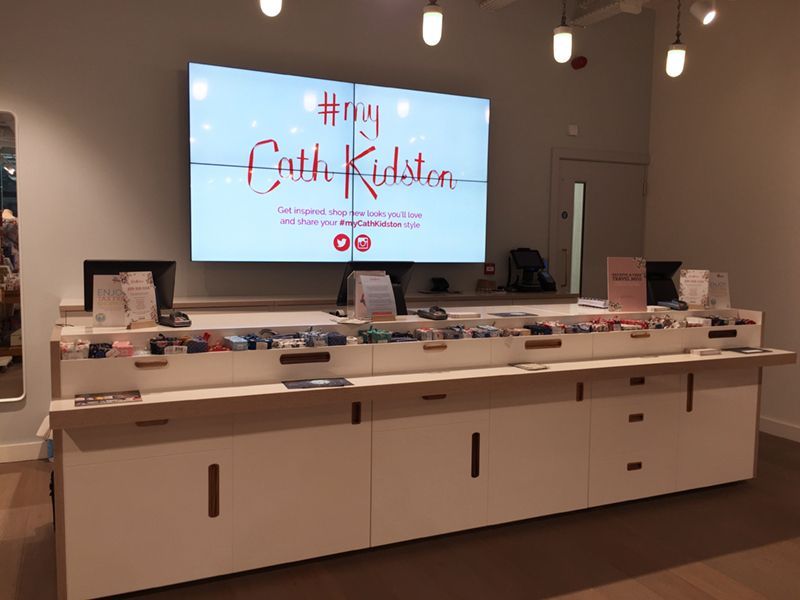 A large screen in a store says faith kristen