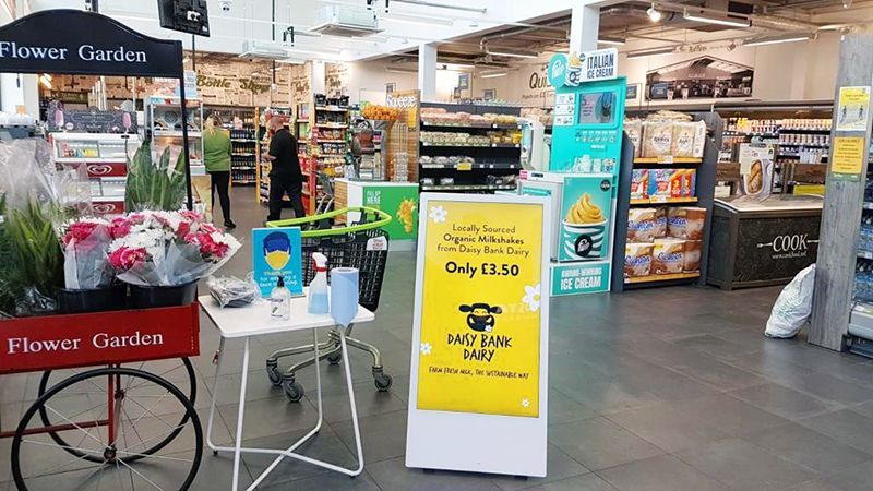 A store filled with lots of flowers and a table with a phone on it.
