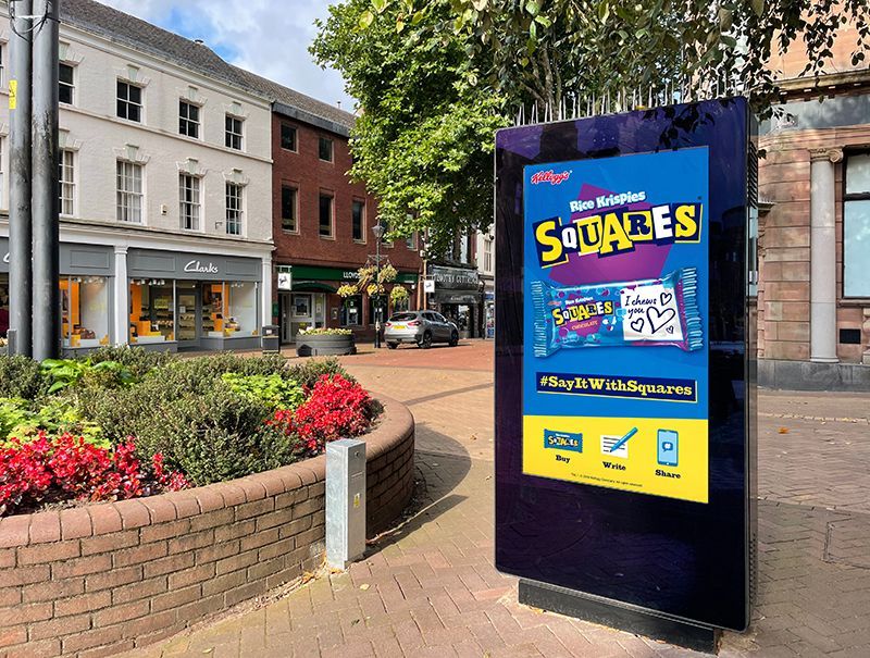 A sign that says squares on it is in front of a brick building.