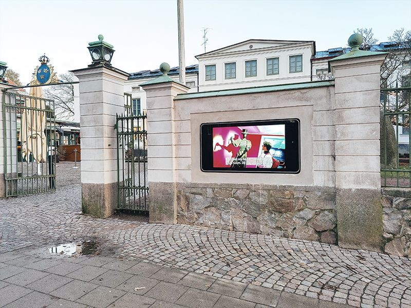 A large screen is mounted on the side of a building