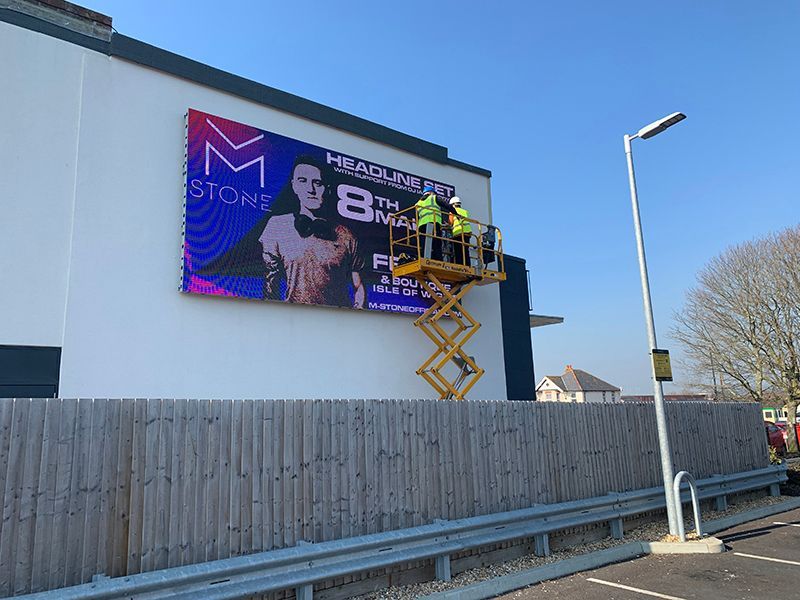 A large billboard is being installed on the side of a building.