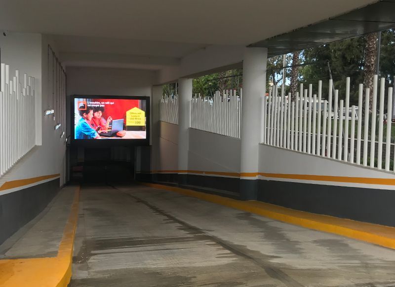 A parking garage with a large flat screen tv on the wall.