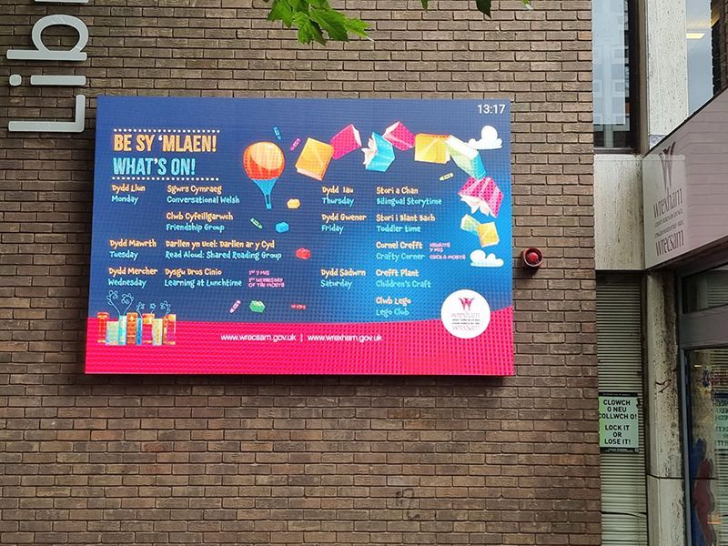 A large sign on a brick wall that says