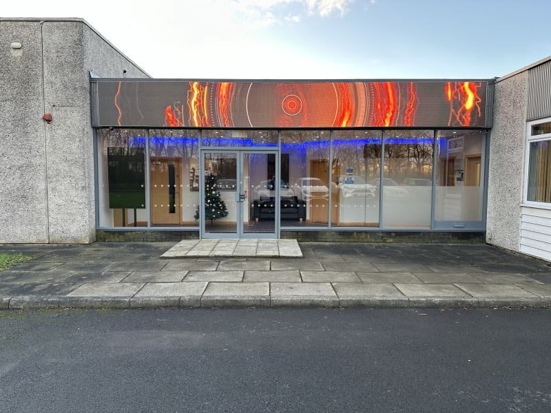 A large building with a lot of windows and a christmas tree in front of it.