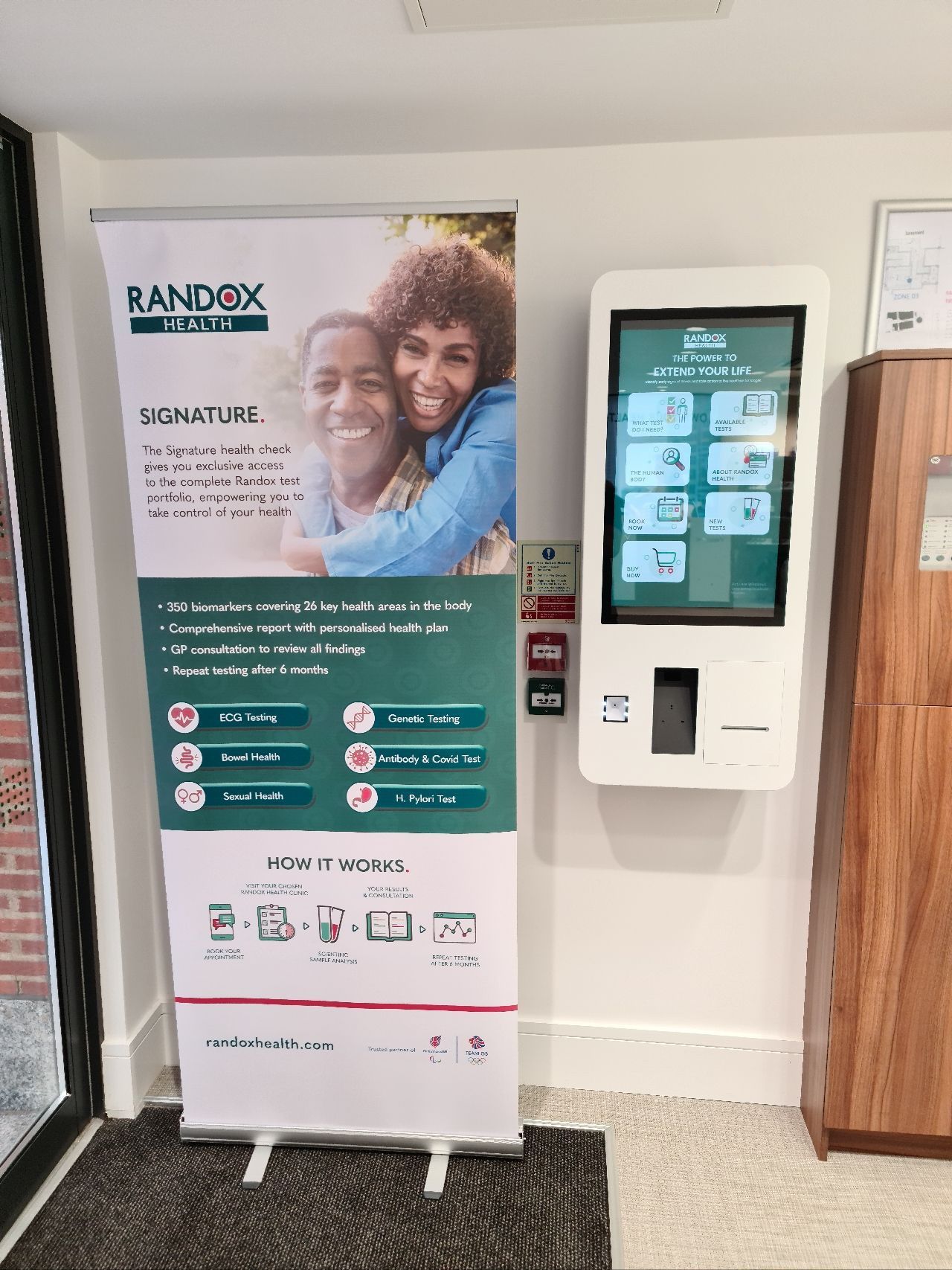 A kiosk with a picture of a man and woman hugging next to a sign.