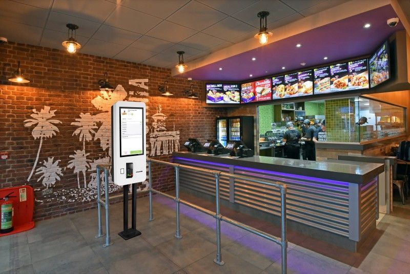 A fast food restaurant with a brick wall and a purple ceiling.
