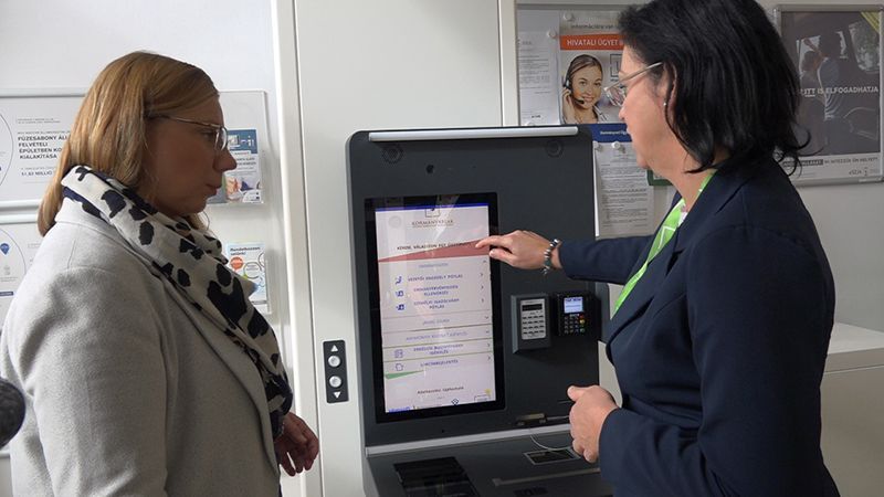 Two women are standing next to each other in front of a machine.