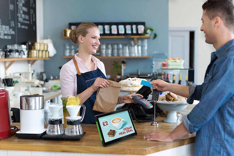 A man is paying for a meal at a restaurant with a credit card.
