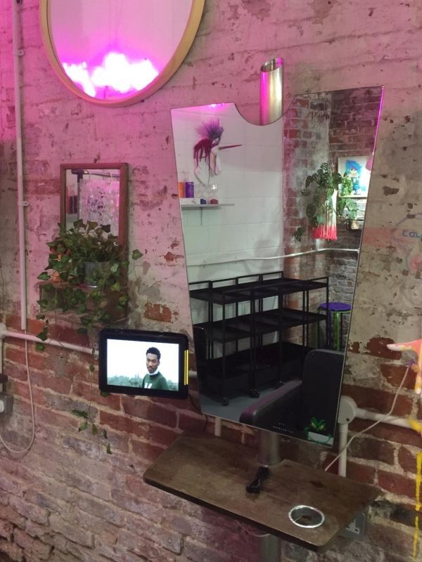 A brick wall with a mirror and a tv on it
