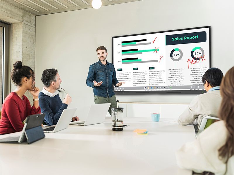 A man is giving a presentation to a group of people in a conference room.