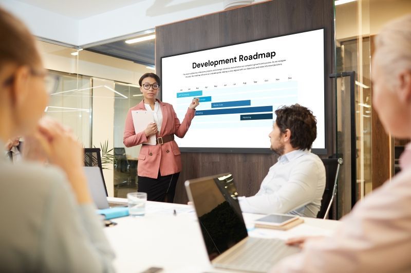 A woman is giving a presentation to a group of people in a conference room.