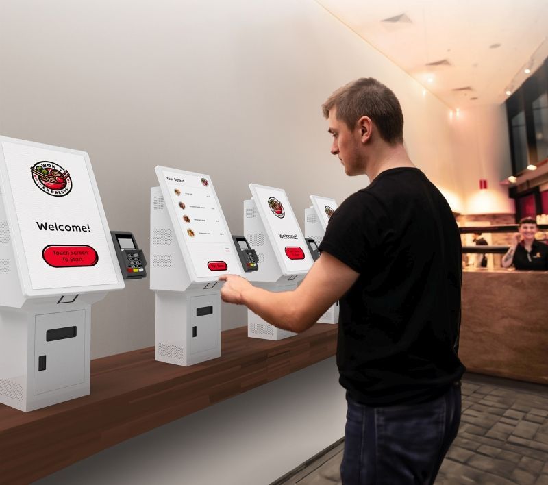 A man is using a machine that says welcome