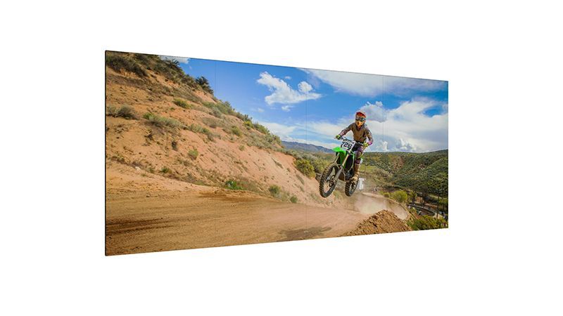 A man is riding a dirt bike on a dirt road.