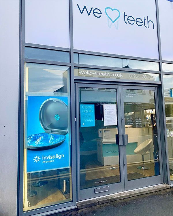 The front of a dental office with a sign that says `` we love teeth ''.