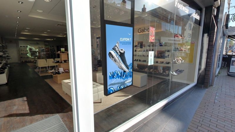 A store window with a picture of a pair of shoes on it.