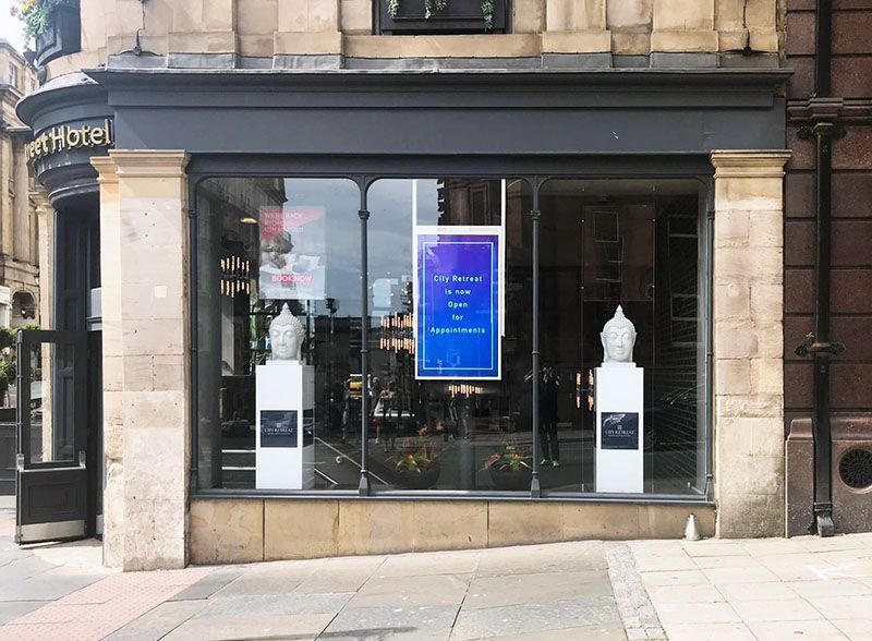 A store front with a blue sign on the window.