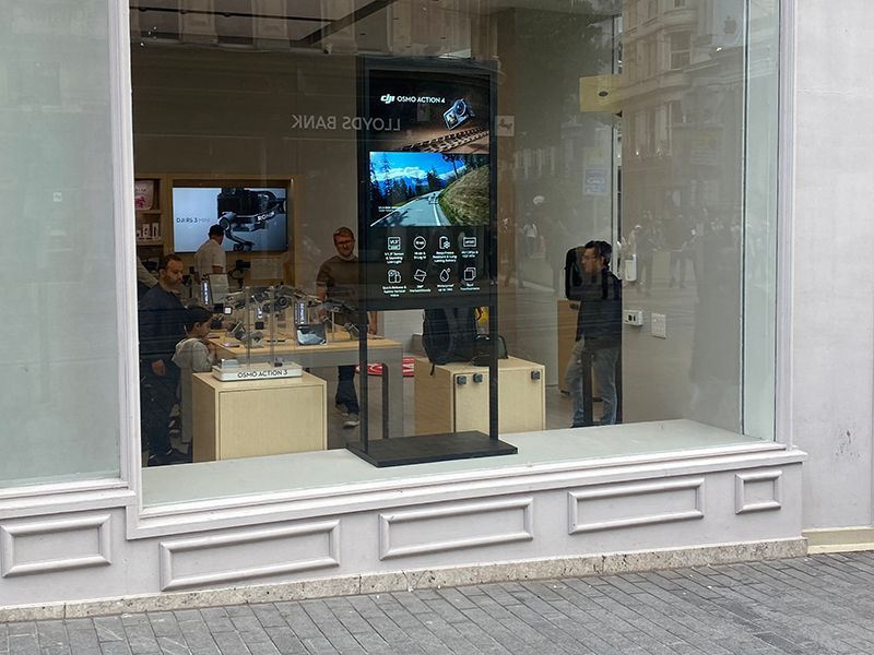 A store front with a large screen in the window
