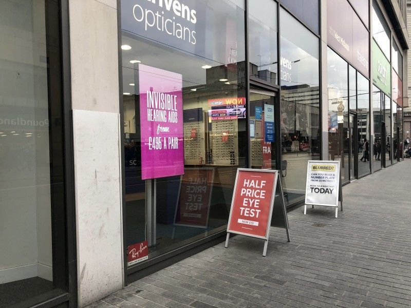 A store front with a sign that says `` half price eye test ''.