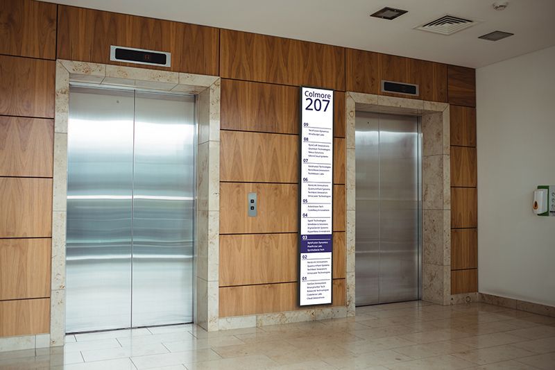 Two elevators in a building with a sign on the wall that says 207