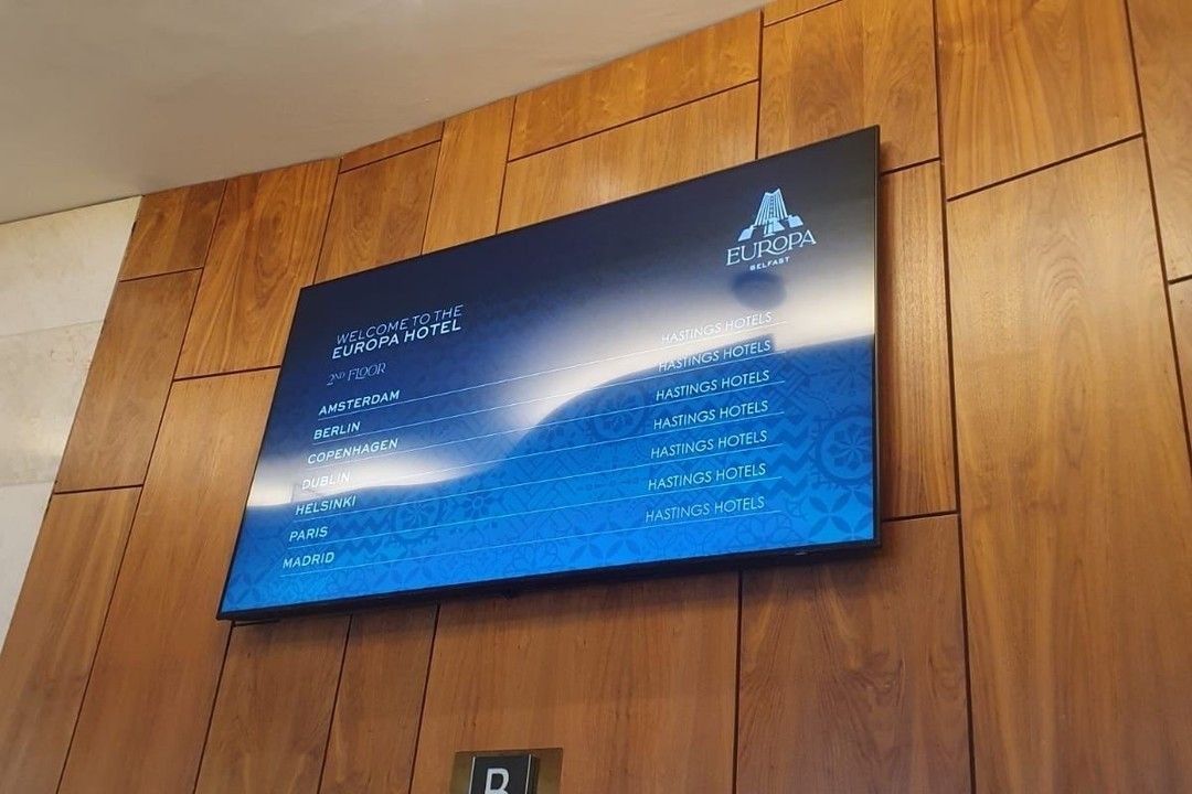 A large screen is hanging on a wooden wall.